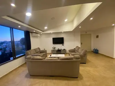 a living room with two couches and a flat screen tv at The view IV in Amman