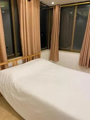 a bed in a room with two windows at The view II in Amman