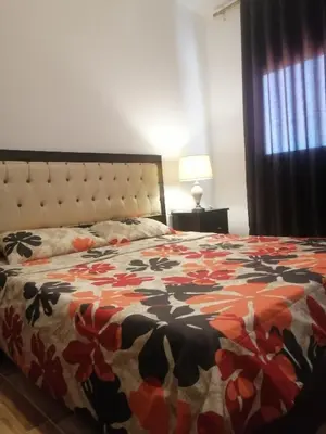 a bedroom with a bed with a floral bedspread at The Stunning View in Wadi Musa