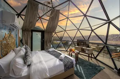 a bedroom with a bed and a large glass window at Petra Seasons luxury Resort in Al Ḩayy