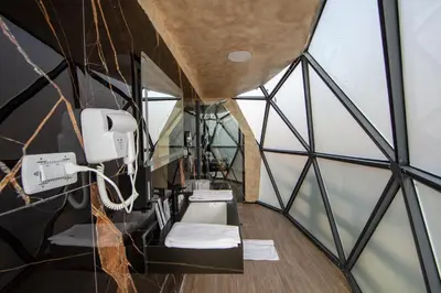 a bathroom in a glass building with mirrors at Petra Seasons luxury Resort in Al Ḩayy