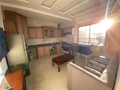 a kitchen with a couch and a table in a room at Treasury Terrace Apartments in Wadi Musa