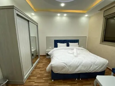 a bedroom with a large white bed in it at Treasury Terrace Apartments in Wadi Musa