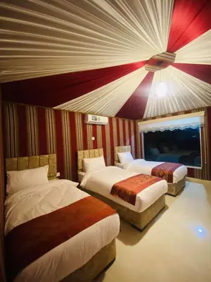 two beds in a room with red and purple walls at WADi RUM LUXURY RITZ in Wadi Rum