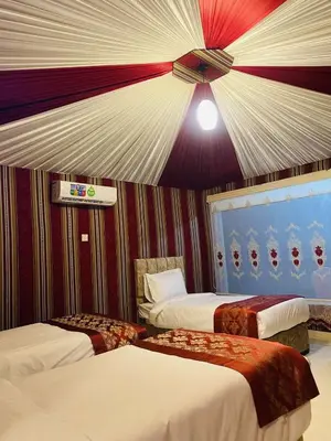 a hotel room with two beds and a ceiling at WADi RUM LUXURY RITZ in Wadi Rum