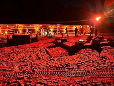 a group of people standing in a desert at night at WADi RUM LUXURY RITZ in Wadi Rum