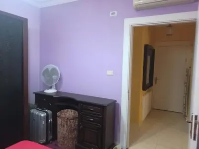 a room with purple walls and a table with a fan at Dream Home in Amman