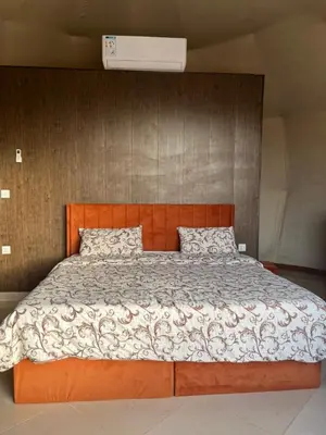 a bedroom with a large bed with a wooden headboard at Al Raha Luxury Camp in Wadi Rum