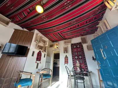 a room with a table and chairs and a ceiling at Antica old apartment al-lwebdeh in Amman