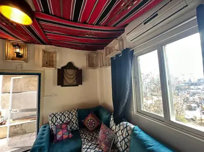 a living room with a couch and a window at Antica old apartment al-lwebdeh in Amman