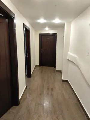 an empty hallway with two doors and wooden floors at Old Street Apartment in Wadi Musa
