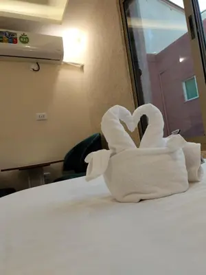 a towel in the shape of a heart sitting on a bed at Old Street Apartment in Wadi Musa
