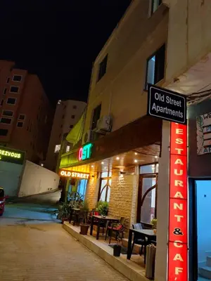 a sign on the side of a building at night at Old Street Apartment in Wadi Musa