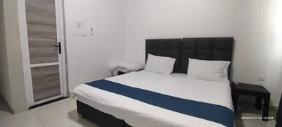 a bedroom with a large bed with a black headboard at Happy Beach For Studio Rooms Apartment شاطئ السعادة للشقق المفروشة in Aqaba