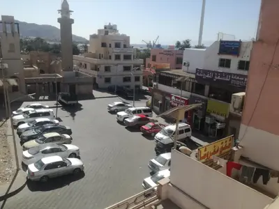 a group of cars parked in a parking lot at Happy Beach For Studio Rooms Apartment شاطئ السعادة للشقق المفروشة in Aqaba