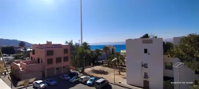 a view of a city with cars parked in a parking lot at Happy Beach For Studio Rooms Apartment شاطئ السعادة للشقق المفروشة in Aqaba