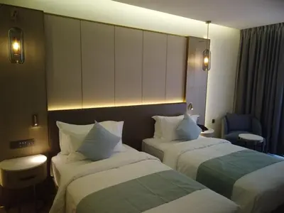 a hotel room with two beds and a chair at H Luxury Hotel in Wadi Musa
