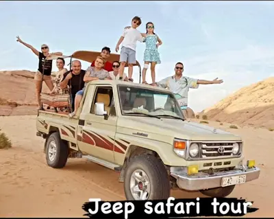 a group of people sitting on the back of a pickup truck at Adel Wadi Rum Camp Bubble in Wadi Rum