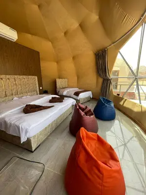 a room with two beds and two bags on the floor at Adel Wadi Rum Camp Bubble in Wadi Rum