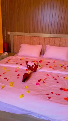 a bed with red rose petals on it at Adel Wadi Rum Camp Bubble in Wadi Rum