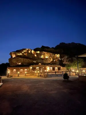 a building with lights in front of a mountain at Adel Wadi Rum Camp Bubble in Wadi Rum