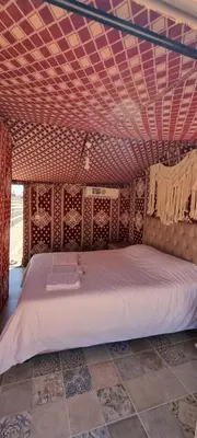 a large bed in a room with a ceiling at Wadi Rum stael Luxury Camp in Wadi Rum