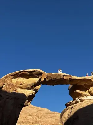 a stone arch in the desert with a blue sky at Wadi Rum stael Luxury Camp in Wadi Rum