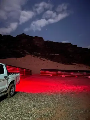 a white truck parked in a room with red lights at Wadi Rum stael Luxury Camp in Wadi Rum