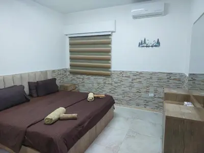 a bedroom with a bed with two stuffed animals on it at Cozy Home 2 in Amman