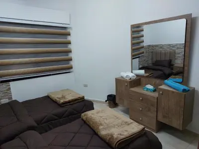 a room with two beds and a large mirror at Cozy Home 2 in Amman