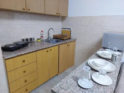 a kitchen with a sink and plates on a counter at Cozy Home 3 in Amman