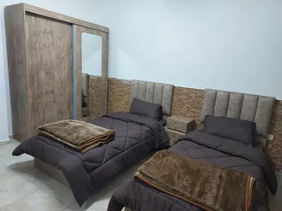 a bedroom with three beds and a mirror at Cozy Home 3 in Amman