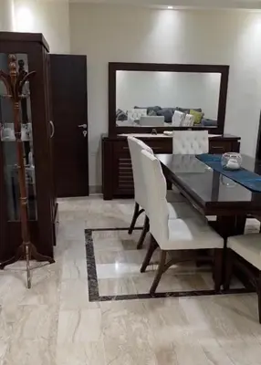 a dining room with a table and chairs and a mirror at Amman Business Park Apartment in Amman