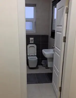 a small bathroom with a toilet and a sink at Amman Business Park Apartment in Amman