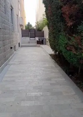 a stone walkway with a bench on the side of a building at Amman Business Park Apartment in Amman