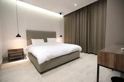 a bedroom with a large white bed and a desk at Zerø Føur DeadSea in Sowayma