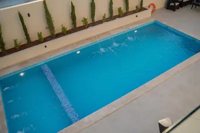 a swimming pool with blue water in a building at Zerø Føur DeadSea in Sowayma