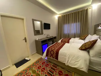 a hotel room with two beds and a mirror at Petra Oleander Hotel in Wadi Musa