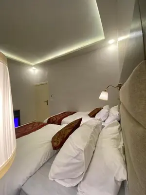 a bedroom with two beds with white sheets and pillows at Petra Oleander Hotel in Wadi Musa