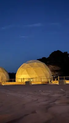 a large domed building in a field at night at Mira Bubble Luxury Camp in Wadi Rum