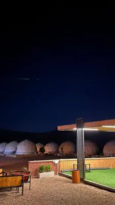 a night view of a park with benches and a building at Mira Bubble Luxury Camp in Wadi Rum