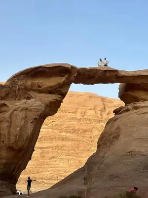two people standing on a bridge in the desert at Wadi Rum Red Sand Camp in Wadi Rum