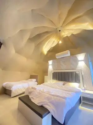 a bedroom with a large bed with a weird ceiling at Wadi rum sky luxury in Wadi Rum