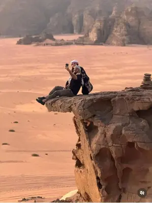 two people sitting on a rock in the desert at Wadi rum sky luxury in Wadi Rum