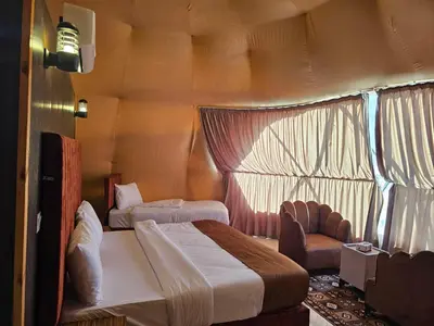 a bedroom with a bed and a chair in a room at Rand desert camp in Wadi Rum