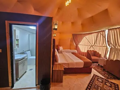 a bedroom with a large bed and a bathroom at Rand desert camp in Wadi Rum