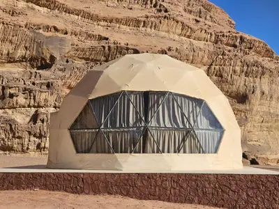 a building in the middle of a desert with a cliff at Rand desert camp in Wadi Rum