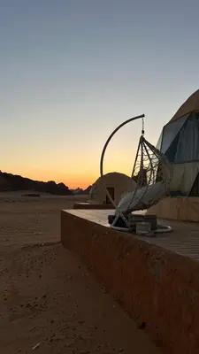 a tent in the desert with the sunset in the background at Rum New Luxury Camp in Wadi Rum