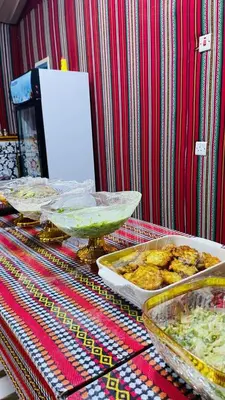 a table with several trays of food on it at Bedouin oasis in Wadi Rum