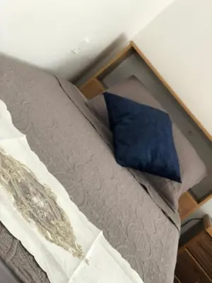 a bed with a blue pillow on top of it at بيت العُمري (ام قيس) in Um Qeis